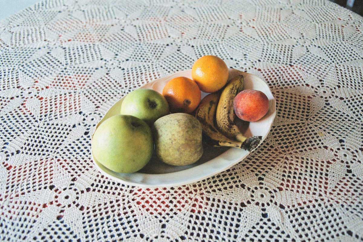 Un plato con frutas sobre un mantel de ganchillo